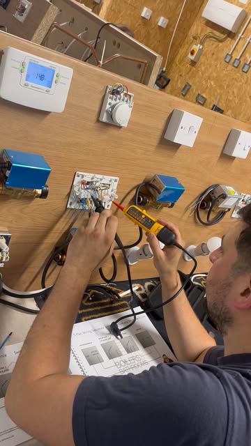 An engineer testing wiring and heating controls