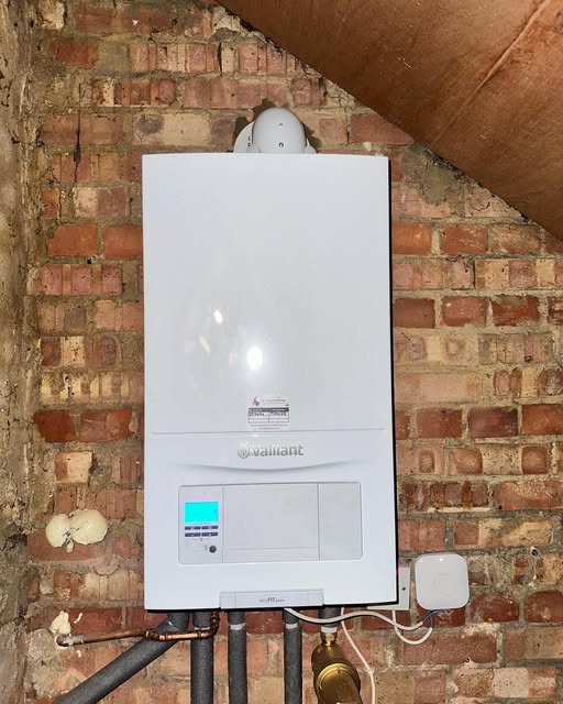 A boiler mounted against exposed brick in a loft conversion