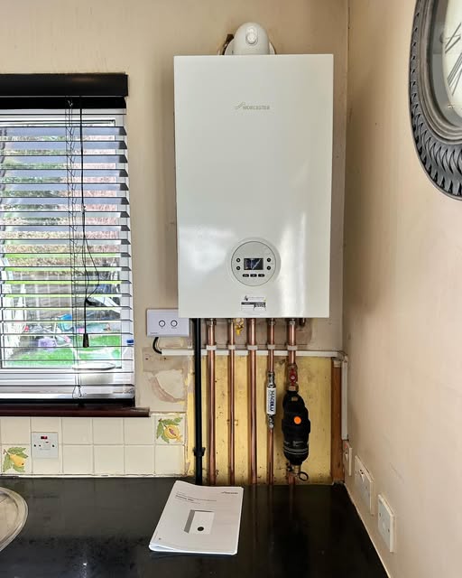 A boiler installed in a kitchen beside a window